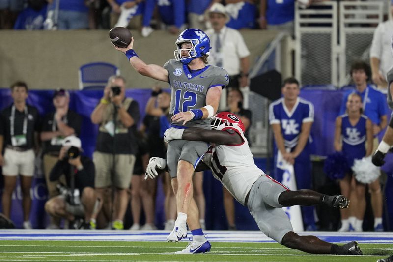 Kentucky quarterback Brock Vandagriff (12) is hit by Georgia linebacker Jalon Walker (11) as he throws during the second half of an NCAA college football game, Saturday, Sept. 14, 2024, in Lexington, Ky. (AP Photo/Darron Cummings)