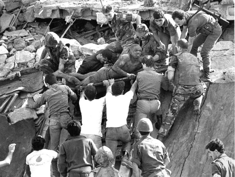 FILE - British soldiers give a hand in rescue operations at the site of the bomb-wrecked U.S. Marine command center near Beirut airport on Oct. 23, 1983. (AP Photo/Bill Foley/File)