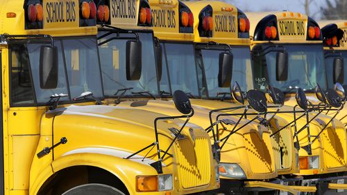 FILE - Public school buses are parked in Springfield, Ill., on Jan. 7, 2015. (AP Photo/Seth Perlman, File)