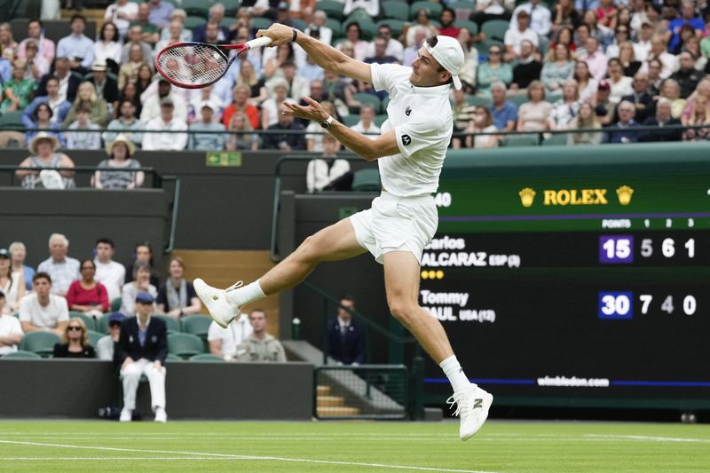 Tommy Paul of the United States plays a forehand return to Carlos Alcaraz of Spain during their quarterfinal match at the Wimbledon tennis championships in London, Tuesday, July 9, 2024. (AP Photo/Kirsty Wigglesworth)