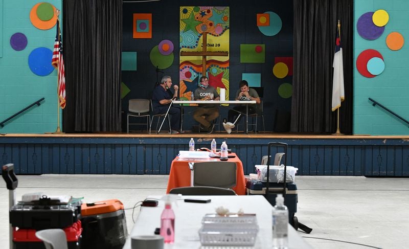 In this file photo, From left, Jim Zvikas, R.N., Riley Erickson, site manager with CORE, and Douglas Ruano, with CORE, eat their lunch as they wait for the last scheduled client showing up at North Springs United Methodist Church in Sandy Springs. (Hyosub Shin / Hyosub.Shin@ajc.com)