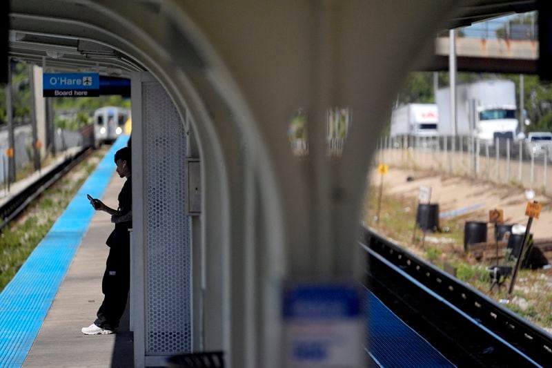 A pedestrian waits on the Eastbound side of the Chicago Transit Authority Blue Line train station at the Harlem Ave., station as a train approaches Chicago, Tuesday, Sept. 3, 2024, in Forest Park, Ill. (AP Photo/Charles Rex Arbogast)