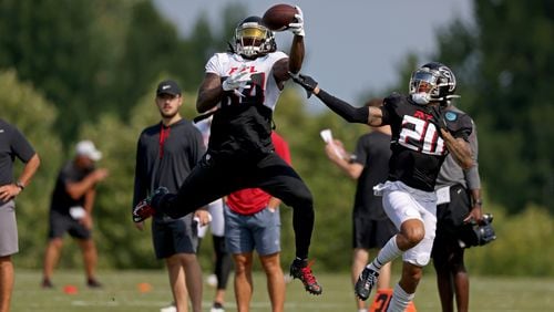 Falcons running back Cordarrelle Patterson makes a one-handed catch against cornerback Teez Tabor during training camp. The Falcons are counting on Patterson to produce this season. (Jason Getz / Jason.Getz@ajc.com)