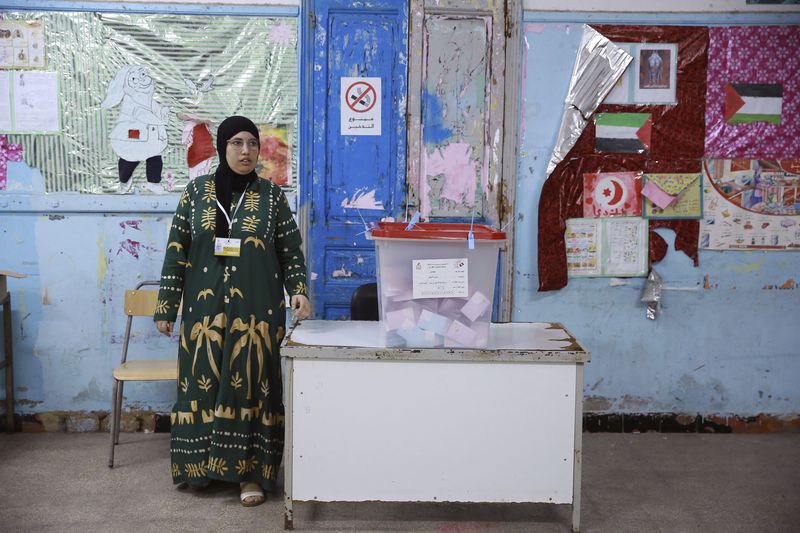 An election official stands next to a ballot box ahead of the vote counting after the presidential elections in the capital Tunis, Tunisia, Sunday, Oct. 6, 2024. (AP Photo/Anis Mili)