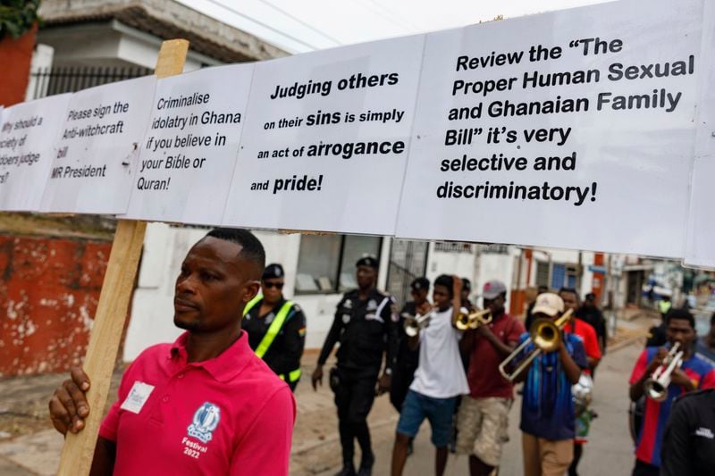 Texas Kadri Moro, the Executive Director of Arise for Justice International, protests with placards nailed on a cross on the street of Accra, Ghana, Thursday Sept 12, 2024. Texas Kadiri Moro is an unusual figure amid the LGBTQ+ rights activists in the coastal West African nation of Ghana. He is heterosexual, married to a woman and a father of six. He is a teacher. And he is a practising Muslim. (AP Photo/Misper Apawu)