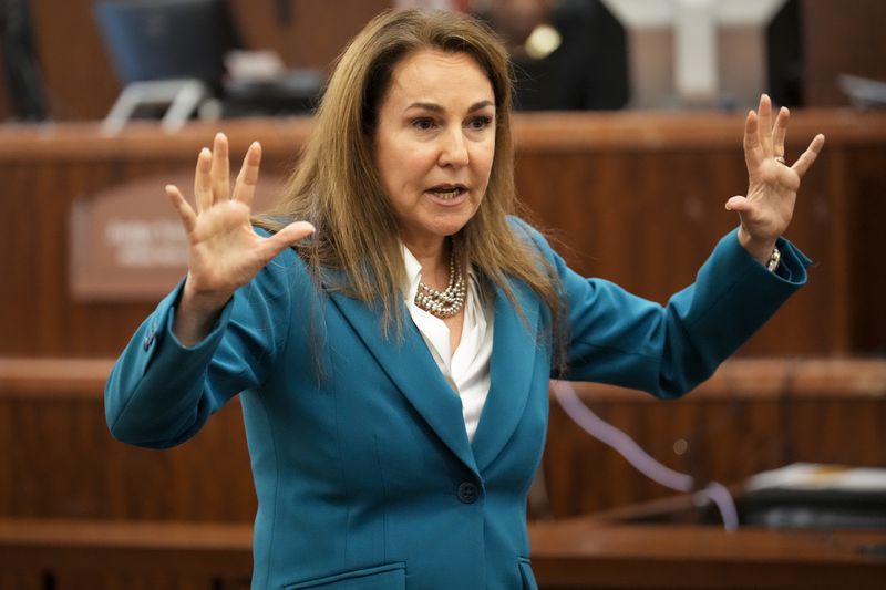 Defense attorney Nicole DeBorde Hochglaube puts her hands up as she tells the jury that Rhogena Nicholas was shot and killed by Houston police officers because she didn't listen to their command and didn't raise her hands when the officers entered her house during the opening statement at Monday, Sept. 9, 2024, at Harris County Criminal Courthouse in Houston. Retired HPD officer Gerald Goines was on trial for two felony murder charges in the January 2019 deaths of Dennis Tuttle and Nicholas during the Harding Street Raid. (Yi-Chin Lee/Houston Chronicle via AP)