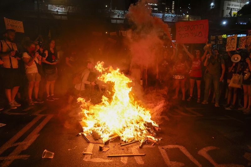 Demonstrators light a bonfire during a protest demanding a cease-fire deal and the immediate release of hostages held by Hamas in the Gaza Strip on Thursday, Sept. 5, 2024, in Tel Aviv, Israel. (AP Photo/Ohad Zwigenberg)