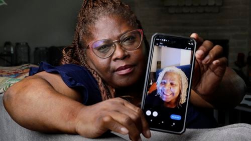 Janet Jarrett shows a photo of her sister, Pamela Jarrett, she keeps on her phone at the home they shared Friday, July 19, 2024, in Spring, Texas. Pamela Jarrett passed away after suffering heat related distress due to the power outage caused by hurricane Beryl. (AP Photo/Michael Wyke)