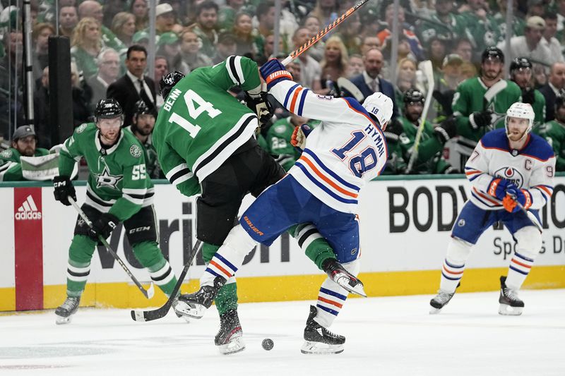 Dallas Stars' Jamie Benn (14) and Edmonton Oilers' Zach Hyman (18) collide while competing for the puck during the second period of Game 1 of the Western Conference finals in the NHL hockey Stanley Cup playoffs Thursday, May 23, 2024, in Dallas. (AP Photo/Tony Gutierrez)