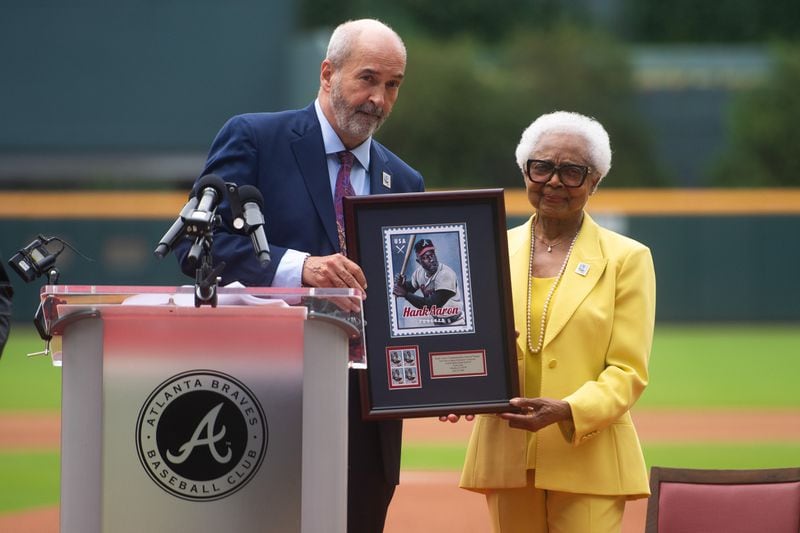 A U.S. Post Office executive posing with Billye Aaron (right) during a ceremony celebrating a new stamp honoring her late husband.