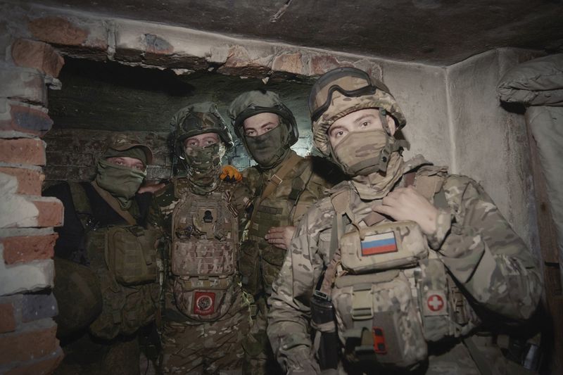 In this photo released by the Russian Defense Ministry Press Service on Tuesday, June 25, 2024, Russian soldiers pose for photo in a shelter at their position in an undisclosed location in Ukraine. (Russian Defense Ministry Press Service via AP)