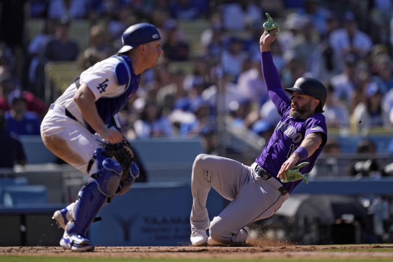 Colorado Rockies' Jake Cave, right, scores on a double by Hunter Goodman as Los Angeles Dodgers catcher Will Smith waits for the ball during the sixth inning of a baseball game, Sunday, Sept. 22, 2024, in Los Angeles. (AP Photo/Mark J. Terrill)