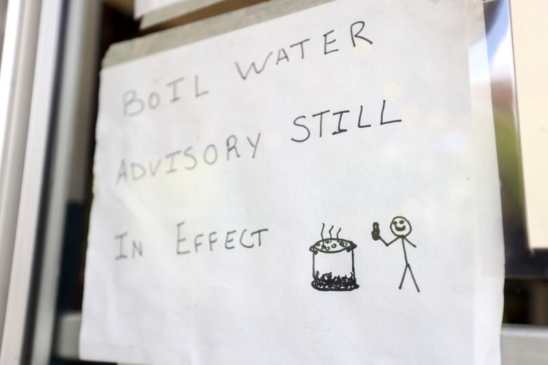 A sign reads, “Boil Water Advisory Still in Effect,” with a drawing of water being boiled and a stick figure with a thumbs up at the main entrance to the restaurant, Sun in my Belly, in the Kirkwood neighborhood, Monday, June 3, 2024, in Atlanta. (Jason Getz / AJC)
