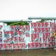 A pedestrian passes a wall of election posters in Maputo, Sunday, Oct. 6, 2024, ahead of elections to be held in Mozambique. (AP Photo/Carlos Uqueio)