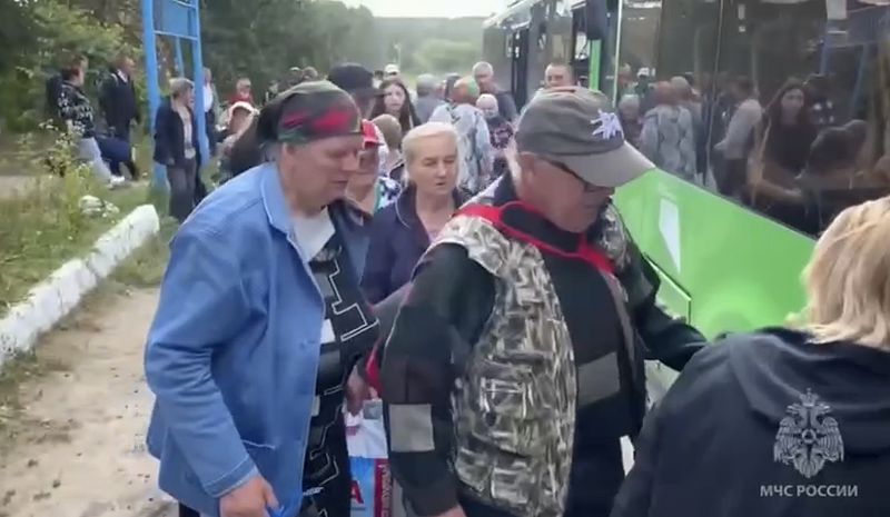 In this image made from video provided by Russian Emergency Situations Ministry press service, people board a bus during evacuation from a fighting between Russian and Ukrainian forces in Belovsky district, Kursk region, Russia, Monday, Aug. 12, 2024. (Ministry of Emergency Situations press service via AP)