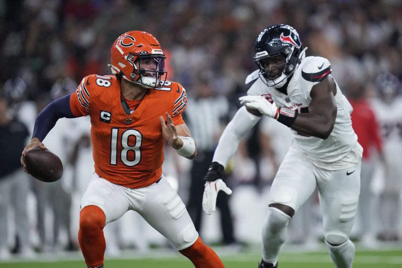 Chicago Bears quarterback Caleb Williams (18) scrambles away from Houston Texans defensive end Will Anderson Jr. during the first half of an NFL football game Sunday, Sept. 15, 2024, in Houston. (AP Photo/Eric Gay)