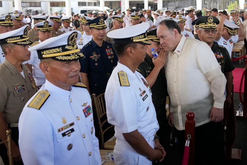 Philippine Defense Secretary Gilberto Teodoro, third right, talks to officers as he attends the 126th Philippine Navy anniversary in Manila, Philippines on Friday, May 24, 2024. The Philippines would press efforts to build security alliances and stage realistic combat drills, including joint naval sails with the United States, Japan and Australia in disputed waters, to defend its territorial interests, Defense Secretary Gilberto Teodoro said Friday, dismissing China's criticisms of such moves as a sign of paranoia. (AP Photo/Aaron Favila)