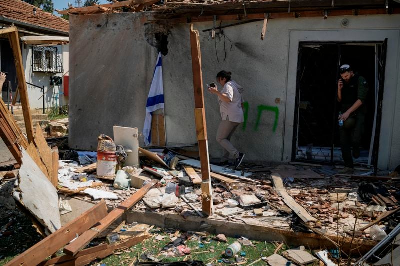 People look at a damaged house that was hit by a rocket fired from Lebanon, near Safed, northern Israel, on Wednesday, Sept. 25, 2024. (AP Photo//Leo Correa)