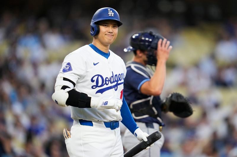 Los Angeles Dodgers designated hitter Shohei Ohtani (17) greets the Tampa Bay Rays dugout during the first inning of a baseball game in Los Angeles, Friday, Aug. 23, 2024. (AP Photo/Ashley Landis)