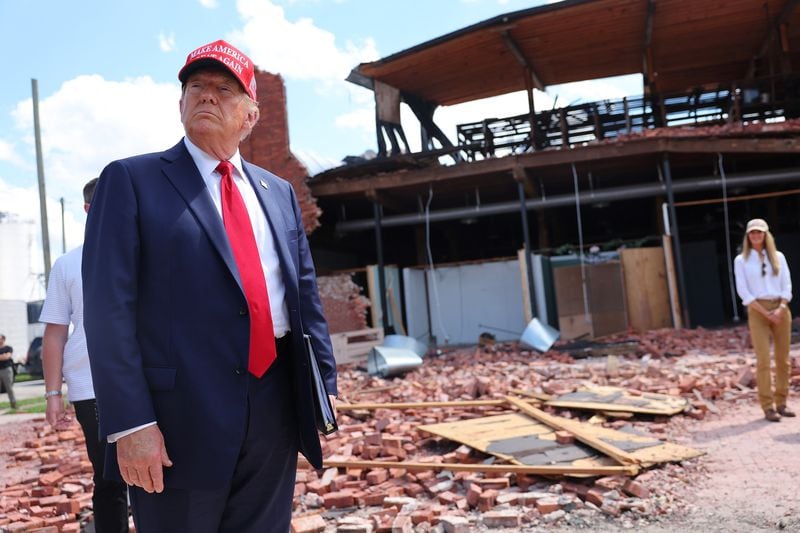 Former U.S. President Donald Trump, the Republican presidential nominee, toured damage Monday in Valdosta and called President Joe Biden’s response lethargic and falsely claimed he was “nonresponsive” to Gov. Brian Kemp. The governor, however, said he spoke to Biden on Sunday and praised the president’s efforts to help Georgia. (Michael M. Santiago/Getty Images/TNS)