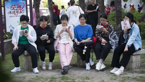 Students review their exam preparation materials in the last minutes before the National College Entrance Exam, or Gaokao, outside an exam venue in Hai'an city in east China's Jiangsu province Friday, June 7, 2024. A 17-year-old vocational school student from rural China in Jiangsu province has become a celebrity on Chinese social media after getting into the final round of a math competition, beating many others from elite universities while raising questions about the education system. . (Chinatopix via AP)