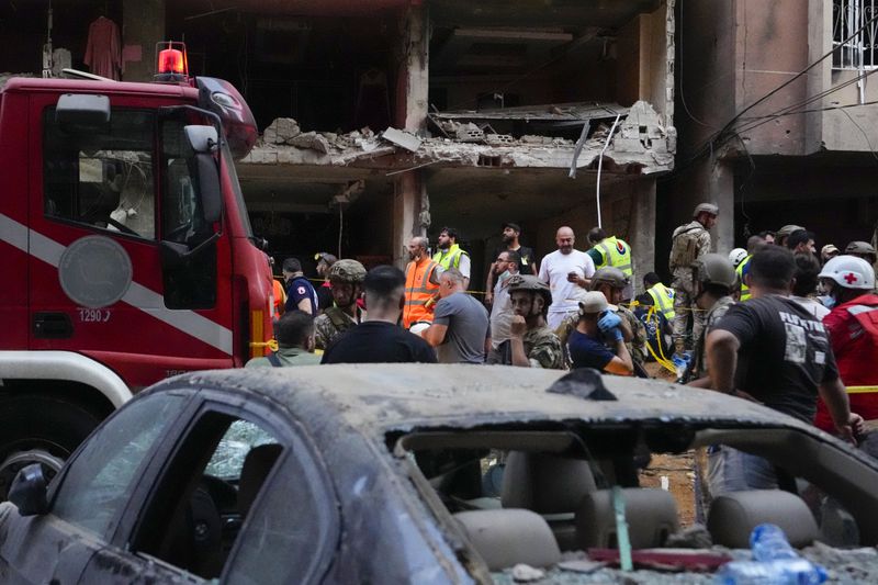 Rescuers work at the scene of an Israeli missile strike in the southern suburbs of Beirut, Friday, Sept. 20, 2024. (AP Photo/Hassan Ammar)