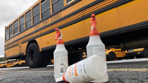 Cleaning supplies sit outside a school bus as bus drivers disinfect the vehicles at DeKalb County School District headquarters in Stone Mountain. (Marlon A. Walker)