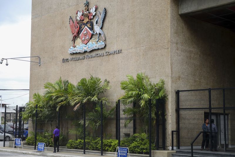 The country's coat of arms hangs on the facade of a government building in Port-of-Spain, Trinidad and Tobago, Tuesday, Aug. 20, 2024. Prime Minister Keith Rowley announced on Sunday, Aug. 18, 2024, that the country is redrawing the island's coat of arms to remove references to European colonization, replacing Christopher Columbus' three ships with the steelpan, a popular percussion instrument. (AP Photo/Ash Allen)