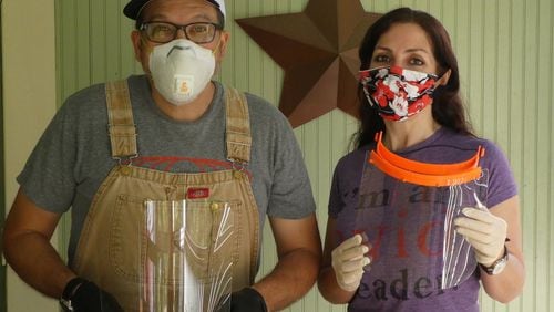 Chris and Deirdre Sugiuchi with face shields they made in their Athens home. Contributed by Deirdre Sugiuchi.