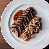 The short rib from Austin's at Serenbe comes brushed in fermented honey and served with crushed herbs, potatoes, chilis, garlic and pickled shallots. / Courtesy of Erik Meadows Photography