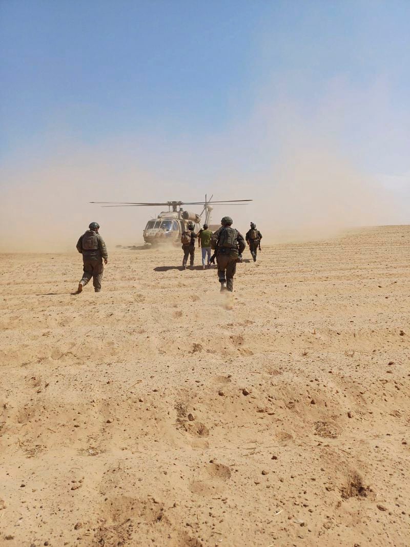 In this photo released by Israeli Defense Forces on Tuesday, Aug. 27, 2024, Israeli soldiers walk with Qaid Farhan Alkadi toward a military helicopter during the rescue operation. (Israeli Defense Forces via AP)