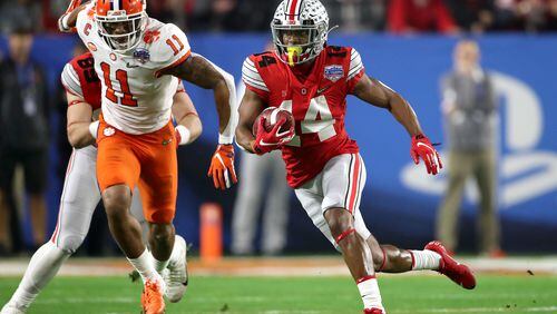 GLENDALE, ARIZONA - DECEMBER 28:  K.J. Hill #14 of the Ohio State Buckeyes carries the ball against Isaiah Simmons #11 of the Clemson Tigers in the first half during the College Football Playoff Semifinal at the PlayStation Fiesta Bowl at State Farm Stadium on December 28, 2019 in Glendale, Arizona. (Photo by Christian Petersen/Getty Images)
