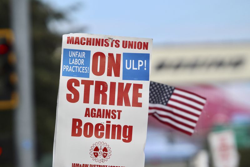 A strike sign is waved at union machinist picket line near Boeing's factory in Everett, Washington, Thursday, Sept. 19, 2024. (AP Photo/Manuel Valdes)