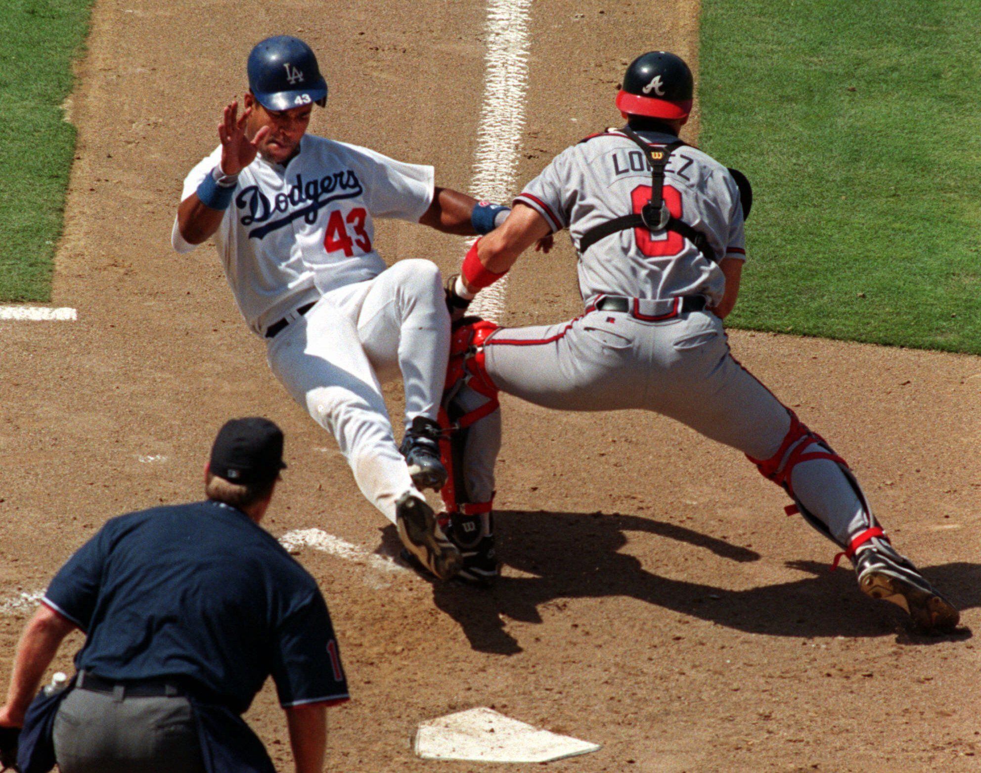 Atlanta Braves' Javy Lopez, carrying a model airplane, walks off the field  in the rain at Turner Field in Atlanta, Monday, Oct. 4, 1999. The Braves  cancelled practice Monday due to the