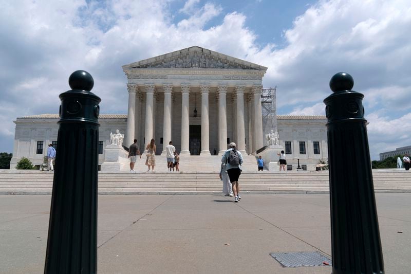 Visitors pose for photographs outside the U.S. Supreme Court Tuesday, June 18, 2024, in Washington. ( AP Photo/Jose Luis Magana)