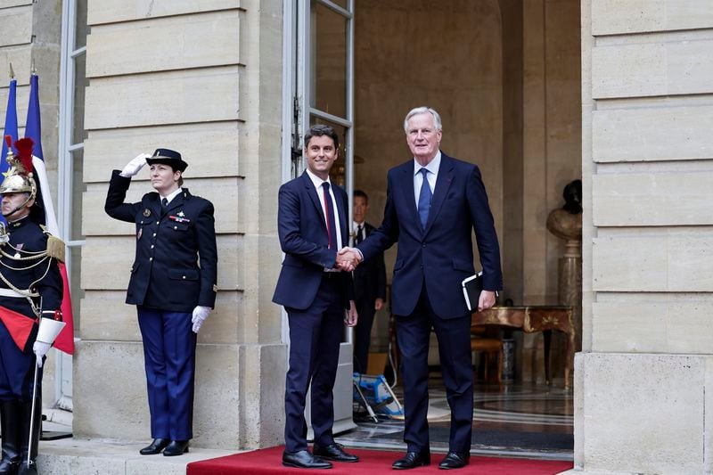 New French prime minister Michel Barnier, right, shakes hands with outgoing prime minister Gabriel Attal during the handover ceremony, Thursday, Sept. 5, 2024 in Paris. President Emmanuel Macron has named EU's Brexit negotiator Michel Barnier as France's new prime minister after more than 50 days of caretaker government. (Stephane de Sakutin, Pool Photo via AP)