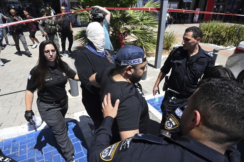 Israeli police arrest a woman outside a shopping mall following a stabbing attack in Karmiel, northern Israel, Wednesday, July 3, 2024. One person was killed and one person wounded in a stabbing attack at a shopping mall in what Israeli police say was a terrorist attack. The police say the assailant was killed. They did not provide the name or nationality of the attacker. (AP Photo/Rami Shlush)