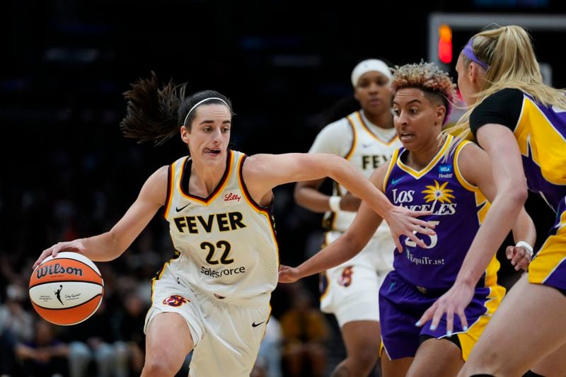 Indiana Fever guard Caitlin Clark (22) controls the ball against Los Angeles Sparks guard Layshia Clarendon (25) during the first half of a WNBA basketball game in Los Angeles, Friday, May 24, 2024. (AP Photo/Ashley Landis)