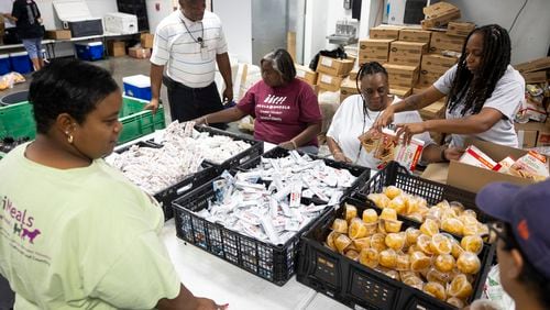 Meals on Wheels employees take advantage of an assembly line to prepare bags of food for clients, Friday, July 12, 2024, in Houston. Staff deliver hot meals as well as shelf stable items to clients daily, many of whom are still without power after Hurricane Beryl. (AP Photo/Annie Mulligan)