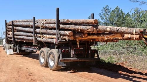 A  log truck prepares to deliver a shipment from a work site in Franklin this month. A Georgia House bill would allow heavier trucks to travel county and state roads. It's sparked a debate over business versus safety.. (Natrice Miller/ Natrice.miller@ajc.com)