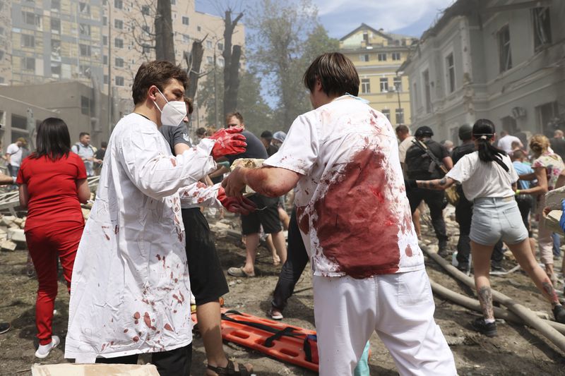 FILE - Rescuers, medical staff and volunteers clean up the rubble and search for victims after a Russian missile hit the country's main children's hospital Okhmatdyt in Kyiv, Ukraine, Monday, July 8, 2024. (AP Photo/Anton Shtuka, File)