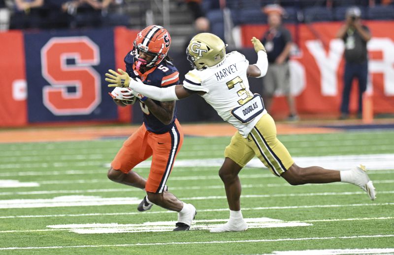 Syracuse wide receiver Umari Hatcher (5) is tackled by Georgia Tech defensive back Ahmari Harvey during the first half of an NCAA football game on Saturday, Sept. 7, 2024, in Syracuse, N.Y. Syracuse won 31-28. (AP Photo/Hans Pennink)