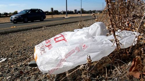 FILE - A plastic bag sits along a roadside in Sacramento, Calif., Oct. 25, 2013. (AP Photo/Rich Pedroncelli, File)