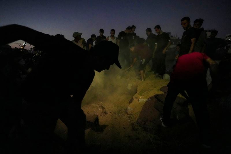 Palestinian mourners bury their loved one at the cemetery in Deir al-Balah, Gaza Strip, Friday, Aug. 9, 2024. (AP Photo/Abdel Kareem Hana)