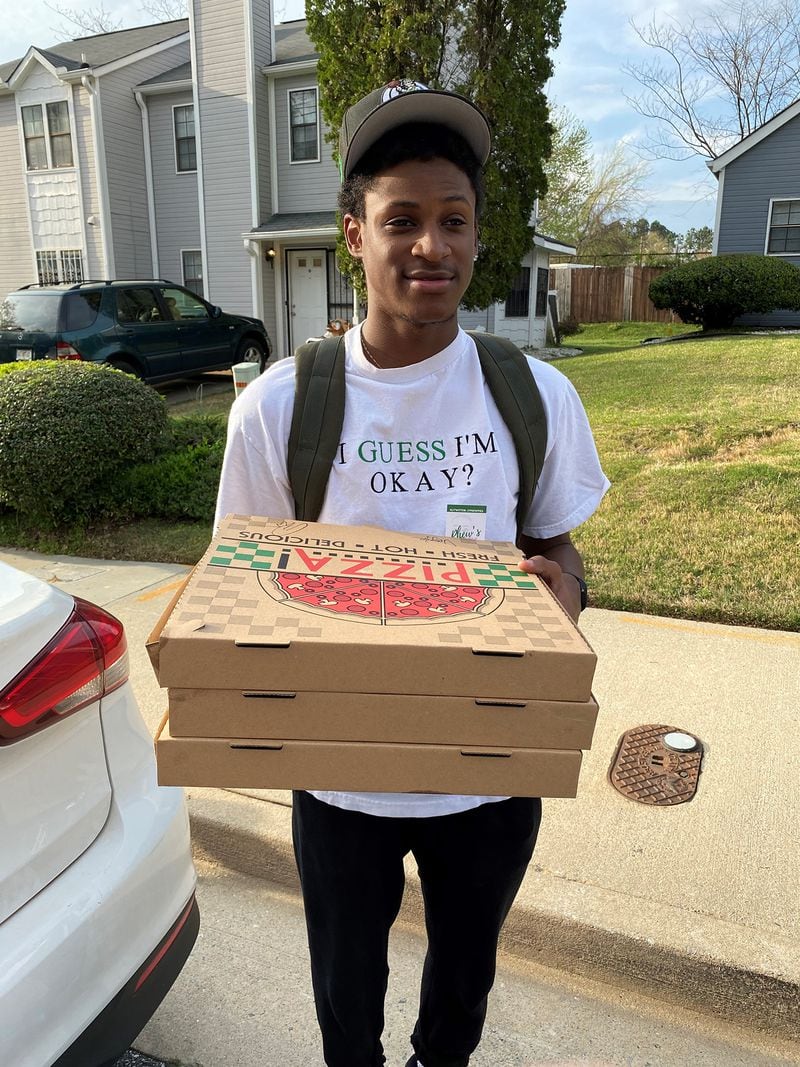 Elijah Lopez brings an order of Phew’s Pies out to a waiting customer. Wendell Brock for The Atlanta Journal-Constitution