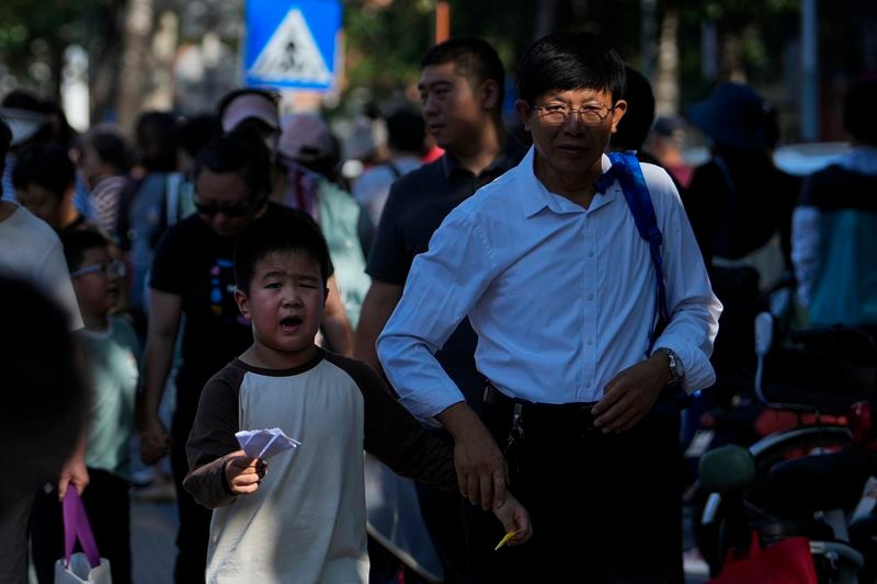 People pick up their children after school in Beijing, Friday, Sept. 13, 2024. (AP Photo/Andy Wong)