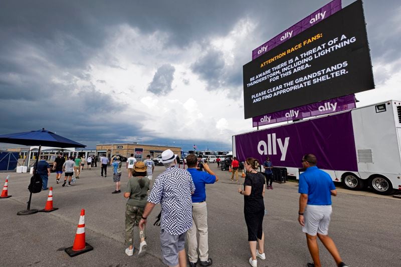 Fans leave the pit area as inclement weather causes a delay during a NASCAR Cup Series auto race, Sunday, June 30, 2024, in Gladeville, Tenn. (AP Photo/Wade Payne)