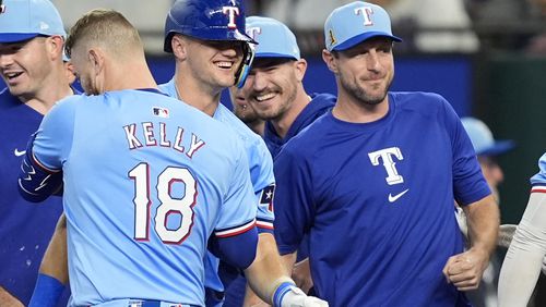 Texas Rangers' Carson Kelly (18), Josh Jung, center, and Max Scherzer, right, celebrate in the 10th inning of a baseball game after the team's 6-5 win against the Minnesota Twins, Sunday, Aug. 18, 2024, in Arlington, Texas. (AP Photo/Tony Gutierrez)