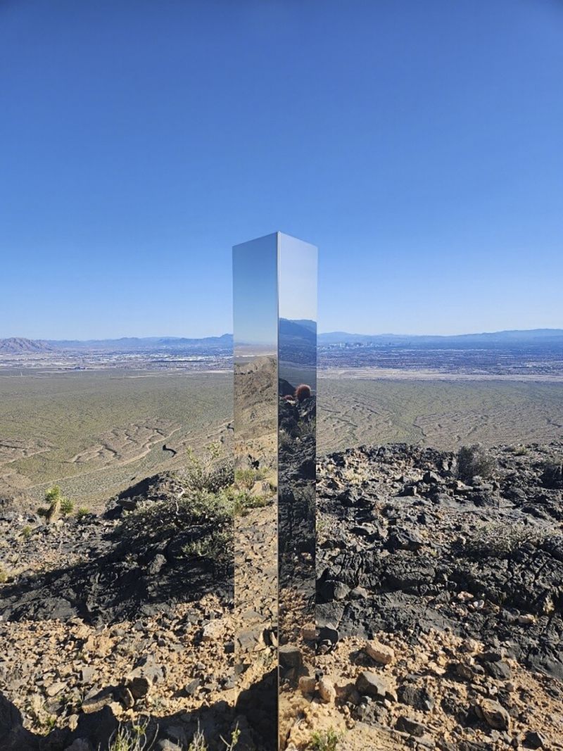 This photo provided by Las Vegas Metropolitan Police Department shows a monolith near Gass Peak, Nev., on Sunday, June 16, 2024. Jutting out of the rocks on a remote mountain peak near Las Vegas, the glimmering rectangular prism's reflective surface imitates the vast desert landscape surrounding the mountain peak where it has been erected. (Las Vegas Metropolitan Police Department via AP)