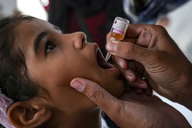 A health worker administers a polio vaccine to a child at a hospital in Deir al-Balah, central Gaza Strip, Sunday, Sept. 1, 2024. (AP Photo/Abdel Kareem Hana)